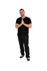 A handsome dark-haired man in a black T-shirt, trousers and sneakers on a white background