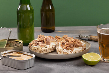 Tuna sandwiches on a table next to lemonade and beer, in a modern interior design
