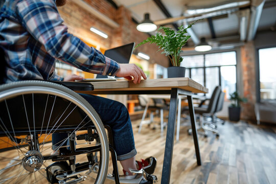 A person using a wheelchair working at a desk in a small, modern office