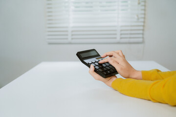 Business financing accounting banking concept. Business woman hand doing finances and calculate on desk about cost at home office. Woman working on desk with using calculator, finance accounting.