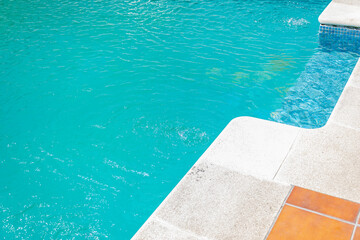 close up of clear blue pool water with bubbling effects and mosaic tiles