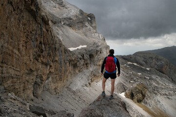 A hiker looking away from Brecha de Rolando towards Casco and Paso de los Sarrios in the Ordesa Park in the Spanish Pyrenees