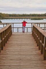 A girl facing away standing on the walkways of the Tablas de Daimiel in Spain