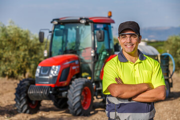 Tractor driver working in an olive field in Andalusia, Spain