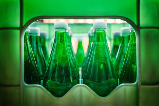 Leere gr&uuml;ne Pfandflaschen mit wei&szlig;en Deckeln in einer Getr&auml;nkekiste. Symbolisiert Recycling, Umweltschutz, Mehrwegsystem, Pfandsystem und nachhaltigen Konsum in Deutschland.