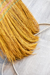 This is a closeup image of a broom placed on a wooden floor