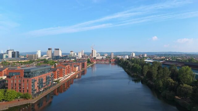 Aerial drone footage of Bute East Dock in the Atlantic Wharf neighbourhood of Cardiff, Wales, with a panoramic view of the city centre in the background. Descending pedestal shot.