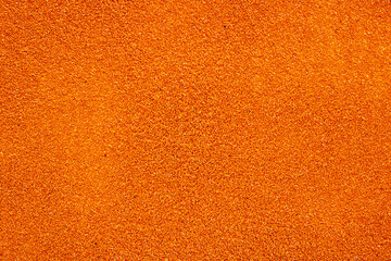 A detailed closeup image showing a vibrant pile of orange glitter