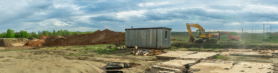 Dynamic Construction Site: Heavy Machinery in Action Under a Dramatic Sky. Innovative...