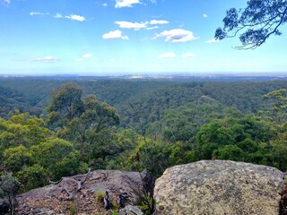 View of the green rolling hills and large rocks of the Blue Mountains from Bowen Mountain, Sydney, Australia