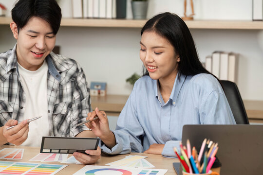 UX and UI Design Collaboration. Two designers discussing color palettes and layouts.