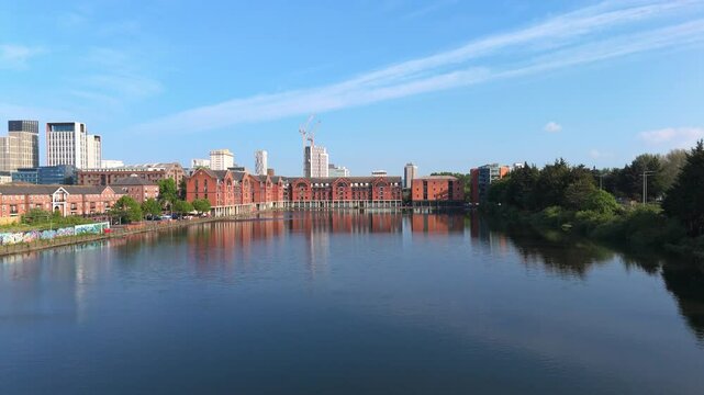 Aerial drone footage of Bute East Dock in the Atlantic Wharf neighbourhood of Cardiff, Wales, with a panoramic view of the city centre in the background. Revealing pull-out shot with vertical ascent.