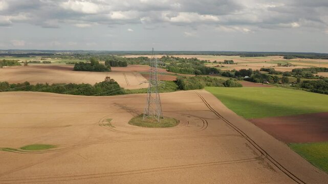 Flying camera circles around tall electric pylon.
