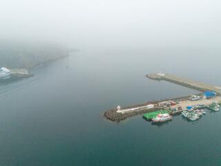 Aerial View of a Misty Harbor with Boats and Jetties. High-angle, full shot of a harbor scene...