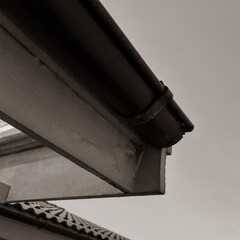 Sepia-toned abstract view of house gutter and roofline — minimal architecture