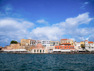 Fototapeta premium Scenic view of the Old Port in Chania, Crete, Greece, with Venetian architecture, calm waters, and a vibrant waterfront. A timeless Mediterranean coastal destination.