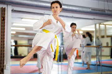 Women athletes learn practice of kata karate punches, hone fighting skills by repeated repetition....