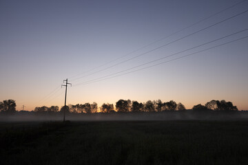 silhouette of electricity power poles at dawn
