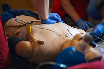 Hands of paramedic and doctor during resuscitation. Team of emergency medical service during CPR training on dummy. Themes rescue, urgency and health care.