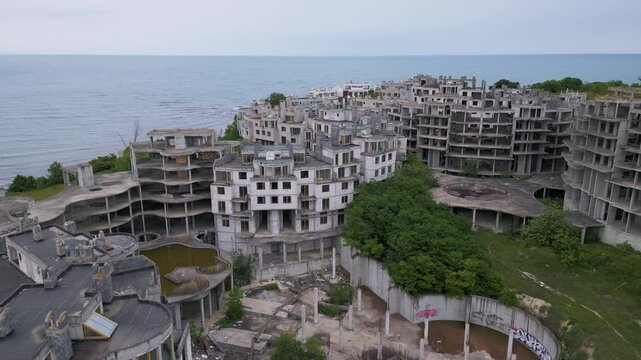 Abandoned hotel complex in Tsarevo, Bulgaria. Aerial view of decaying brutalist buildings overtaken by nature. Urban exploration, urbex, site with eerie, post-apocalyptic atmosphere.