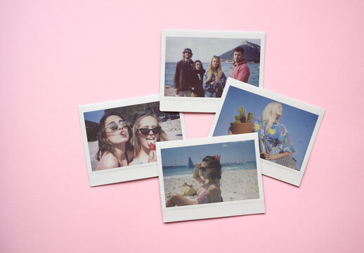 Four blank instant film photos arranged on a pink background. PSD mockup template