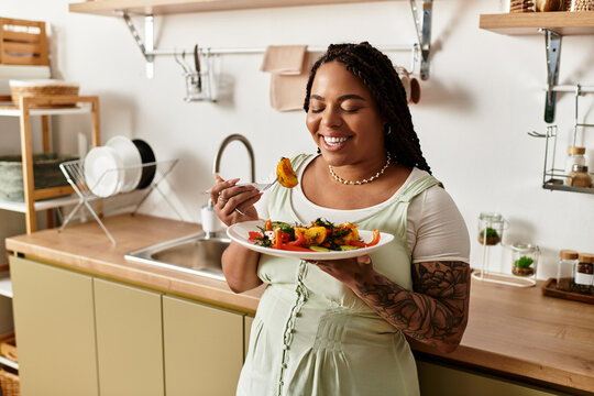 Young woman enjoying a healthy salad in her cozy kitchen during lunch
