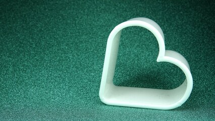Kształt serca na zielonym brokatowym tle © tomo81