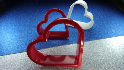 Kształty serc na brokatowym srebrno niebieskim tle © tomo81