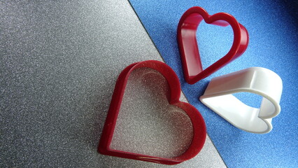 Kształty serc na brokatowym srebrno niebieskim tle © tomo81