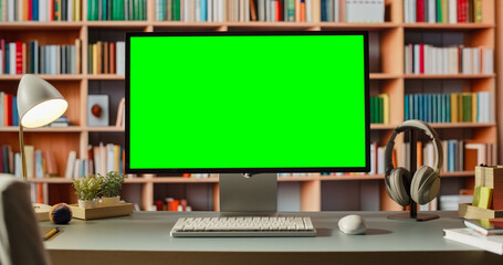 Computer Workstation With Green Screen Monitor Is in Front of Bookshelf. the Desk Contains Keyboard, Headphones, and Various Items for Work or Study