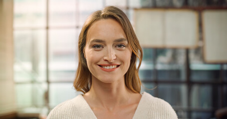 Woman in Cream Sweater Turns, Faces Camera. Contemplative to Confident Transition. Embodiment of Professionalism, Calm Expression of Success. Perfect Woman Looking at Camera