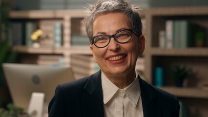 Fototapeta premium Caucasian business woman senior businesswoman laughing smiling joy fun in office mature female worker retired old employer looking at camera smile laugh funny humor joyful carefree emotion cheerful