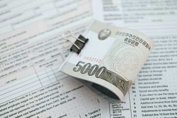 North Korean won money bills in big amount lies on table with tax forms close up