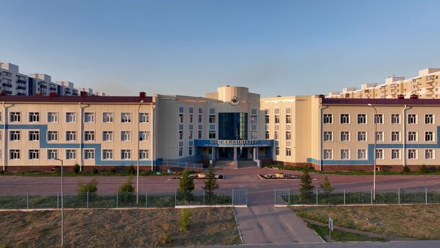 A breathtaking aerial view showcasing a modern residential complex in a vibrant urban setting. School sign in Kazakh "welcome", Karaganda, Kazakhstan July 31, 2024