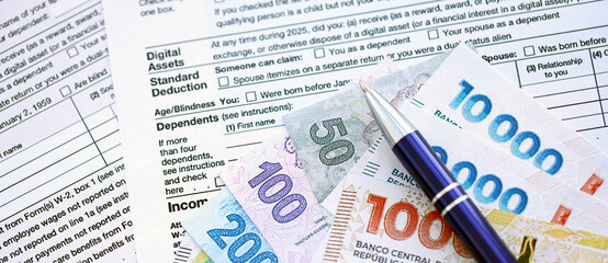 Argentine pesos money bills in big amount lies on table with pen and tax forms close up