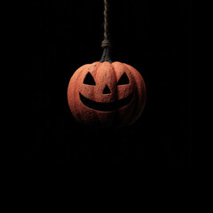 Brightly carved pumpkin hanging in darkness