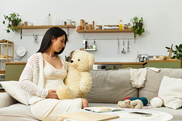 Expecting joy as a beautiful woman embraces her journey with a teddy bear in a cozy living room