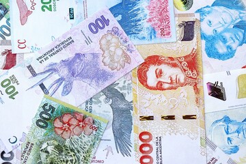 Argentine pesos money bills in big amount lies on white table close up