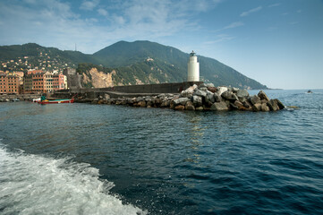Lighthouse at port of coastal town Camogli, colorful architecture in the cozy harbor
