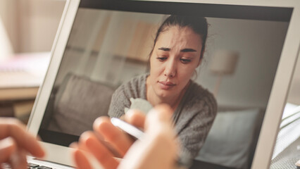 Psychologist calms down emotional crying woman patient by video call on computer