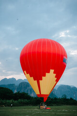 Obraz premium A red hot air balloon is in the air. The balloon is in the sky