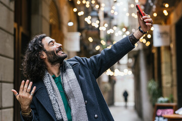 Smiling tourist taking selfie in barcelona gothic quarter with smartphone