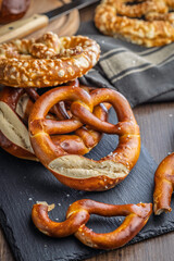Salted bavarian pretzel on cutting board on wooden table.