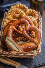 Salted bavarian pretzel in basket on wooden table.