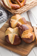 Crunchy bavarian buns on cutting board on kitchen table.