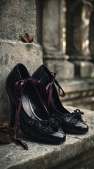 Naklejka premium Vintage black heels with laces resting on stone steps outdoors
