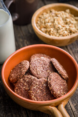 Sweet oatmeal cookies in bowl on wooden table.