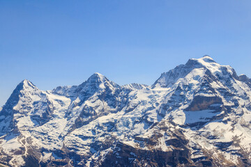 View of three famous Swiss mountain peaks Eiger, Monch and Jungfrau in the Bernese Oberland in...