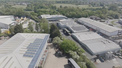 A large industrial area with many buildings and trucks. The buildings are mostly grey and the trucks are mostly orange