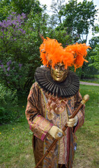 Fototapeta premium Ornate Brown and Orange Carnival Costume with Staff